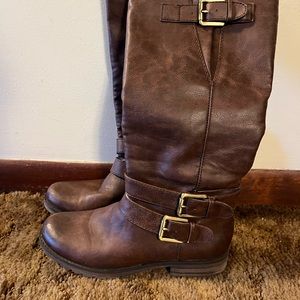 Brown knee high boots, with doubles buckles on sides and one at the top.